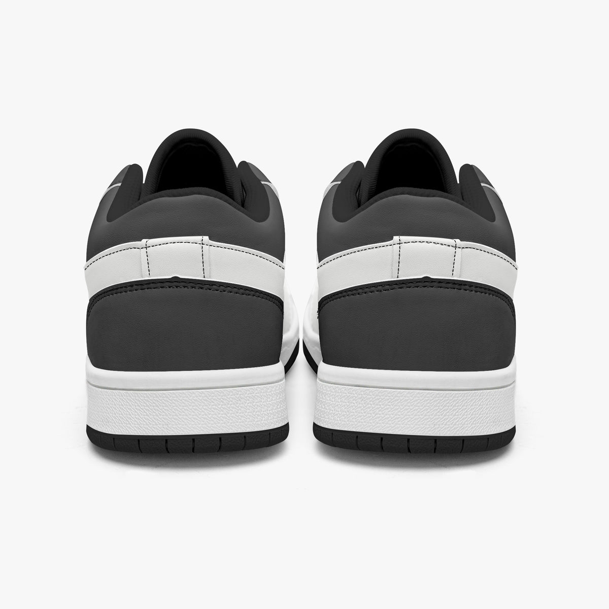 Rear view of black and white sneakers showing dark charcoal heel overlays, white leather collar panels, black interior collar lining, and white midsoles above black outsoles.
