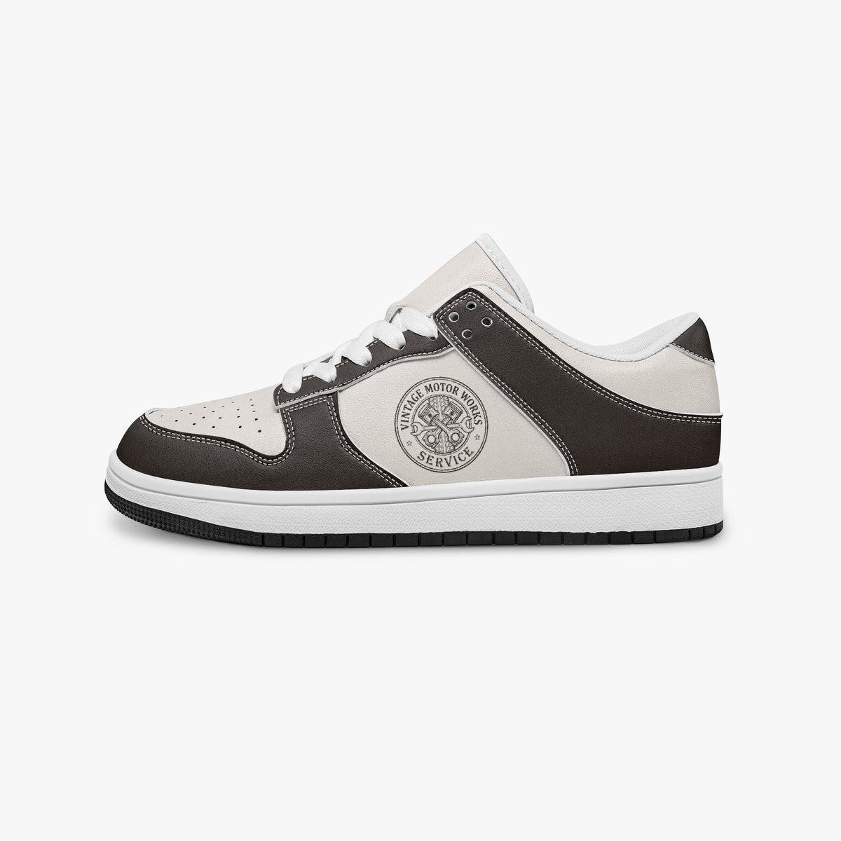 Side profile view of the left sneaker in dark brown and off-white leather, highlighting the "VINTAGE MOTOR WORKS" emblem, white laces, white interior lining, and flat rubber sole facing right.