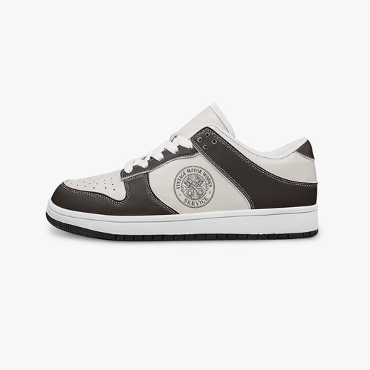 Side profile view of the left sneaker in dark brown and off-white leather, highlighting the "VINTAGE MOTOR WORKS" emblem, white laces, white interior lining, and flat rubber sole facing right.
