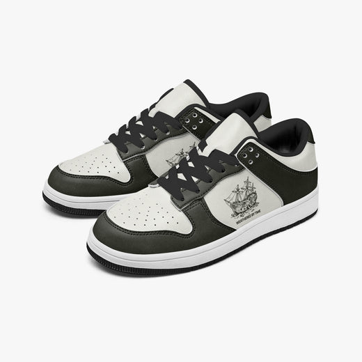 Angled three-quarter view of low-top sneakers in charcoal olive-grey and off-white leather, featuring a vintage sailing shipwreck graphic with "WEATHERED BY TIME", black laces, and a black inner lining.