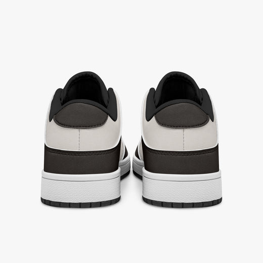 Rear view of dark brown and cream sneakers showing dark brown heel overlays, off-white leather collars, and black interior collar lining above white midsoles.