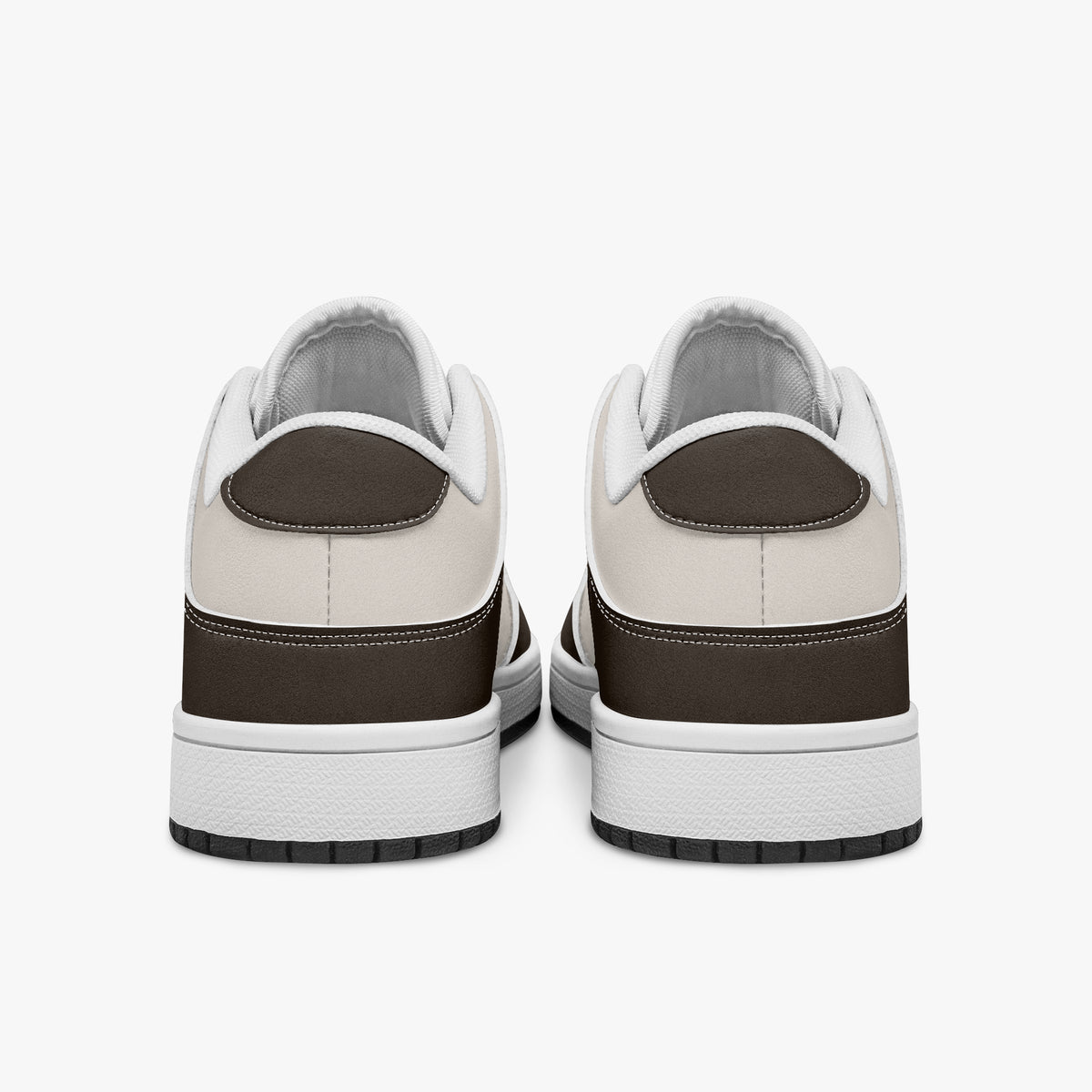 Rear view of dark brown and cream sneakers displaying dark brown heel overlays, off-white leather collar panels, and two-tone white and black rubber outsoles.