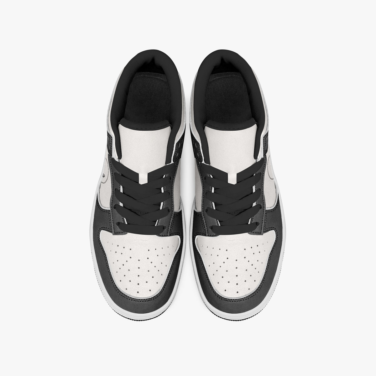Overhead view of black and white sneakers displaying black laces, black padded collar lining, and perforated white leather toe boxes.