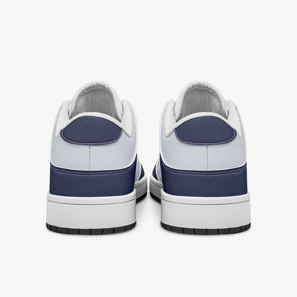 Rear view of navy blue and white sneakers displaying dark navy heel overlays, white leather collar panels, and two-tone white and black rubber outsoles.