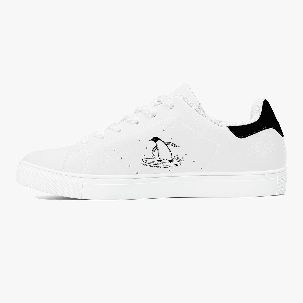 A white low-top sneaker with a black heel tab, featuring a black line-art illustration of a penguin standing on a surfboard on the side, set against a plain white background.