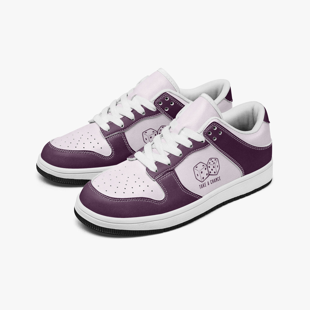 Angled three-quarter view of low-top sneakers in plum purple and pale lilac leather, featuring a pair of dice graphic with "TAKE A CHANCE", white laces, and a white inner lining.