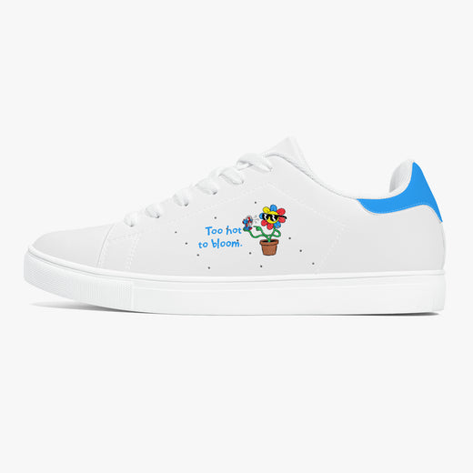 A white low-top sneaker with a blue heel accent, featuring a colorful cartoon flower in a pot and the text 'Too hot to bloom' printed on the side.