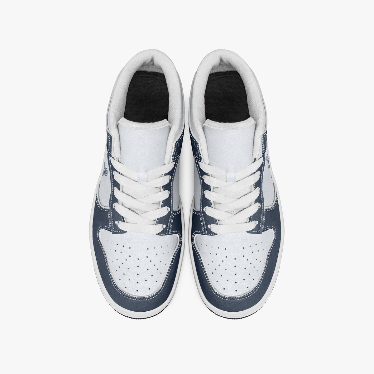 Overhead view of navy blue and white sneakers showing white laces, white padded collars, perforated toe boxes, and white leather uppers.