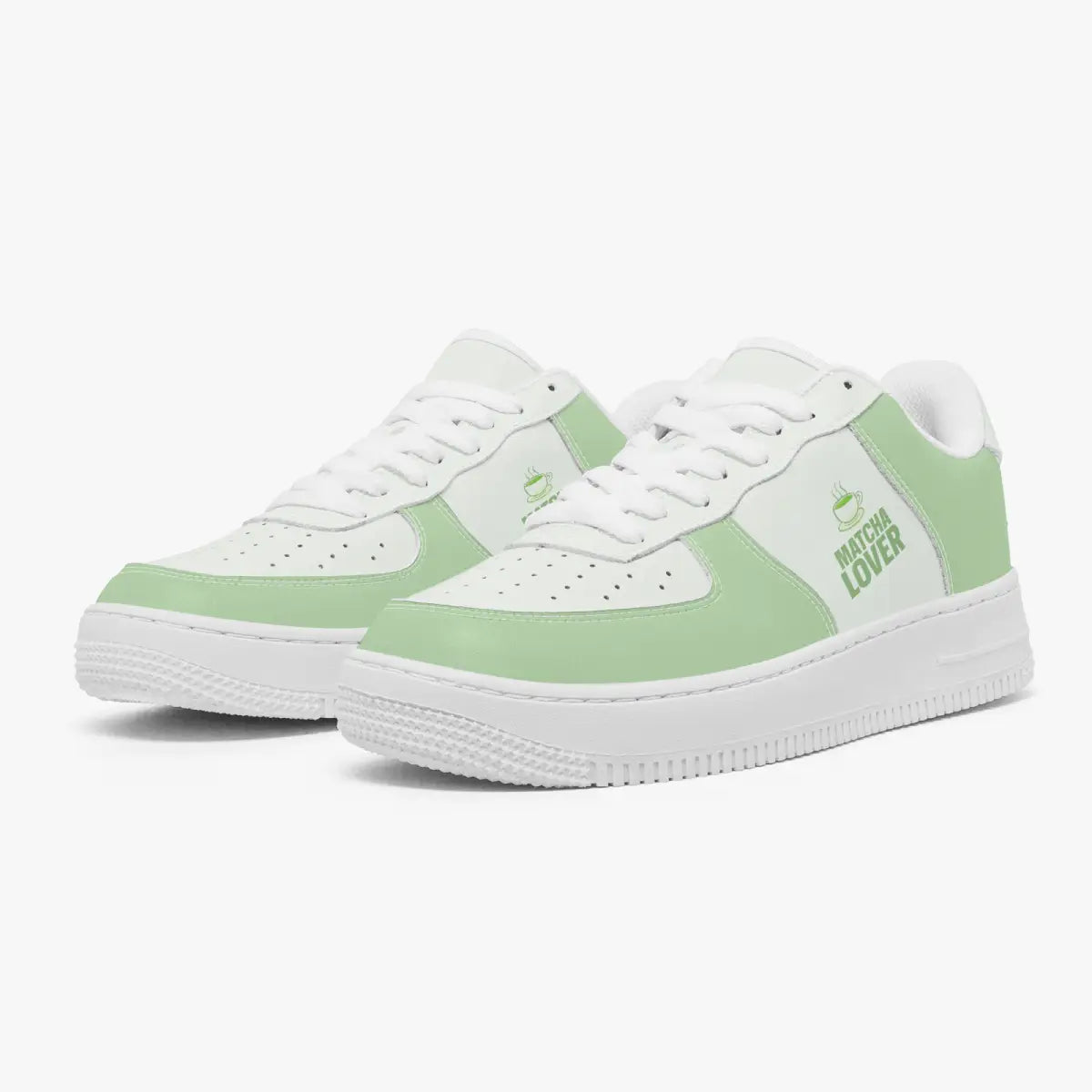 Angled three-quarter view of green and white sneakers featuring a steaming teacup icon and "MATCHA LOVER" graphic printed on the side panel.