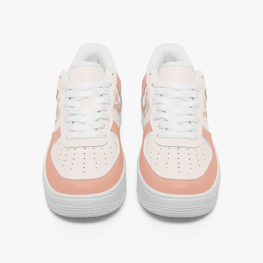 Front view of a pair of dusty peach and off-white low-top sneakers with white laces and perforated toe caps on a plain background.