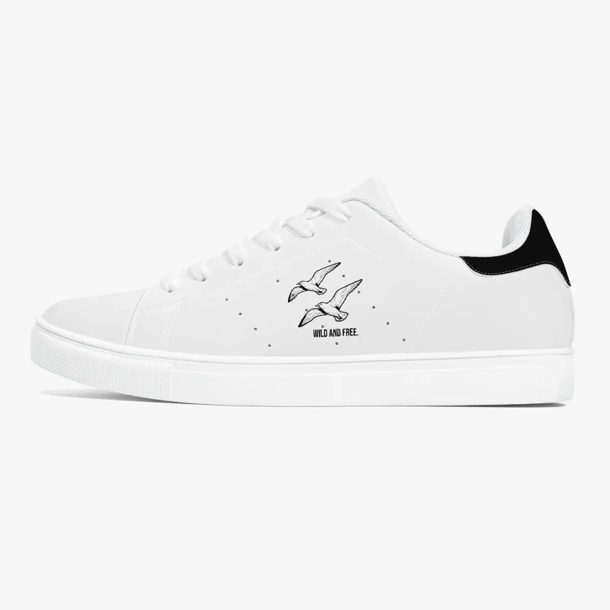 Side profile view of the left sneaker in white leather, showcasing the "WILD AND FREE" soaring birds illustration, black heel tab detail, white laces, and flat white rubber cupsole facing right.