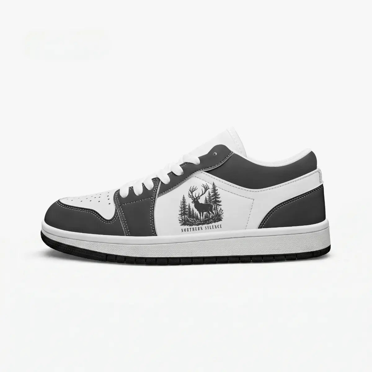 Side profile view of the right low-top sneaker in charcoal black and white leather, featuring a stag deer in a pine forest graphic with "NORTHERN SILENCE", white laces, and a flat rubber sole facing right.
