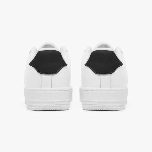 Rear view of white sneakers displaying contrasting black heel tabs, white leather collars, and textured white rubber platform midsoles.
