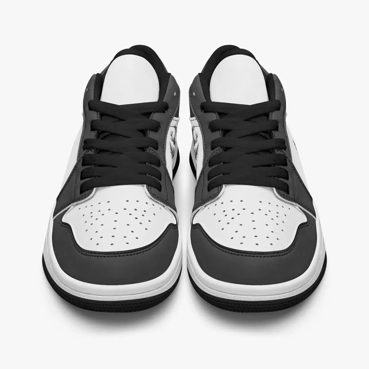 Front-facing top angle of black and white low-top sneakers showcasing black laces, black eyestays, and perforated white toe boxes.