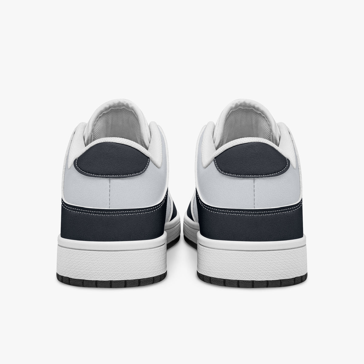 Rear view of navy and white sneakers displaying dark navy heel overlays, white leather collar panels, and two-tone white and black rubber outsoles.