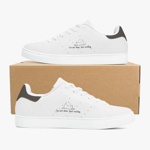 White sneakers with black accents on a cardboard box
