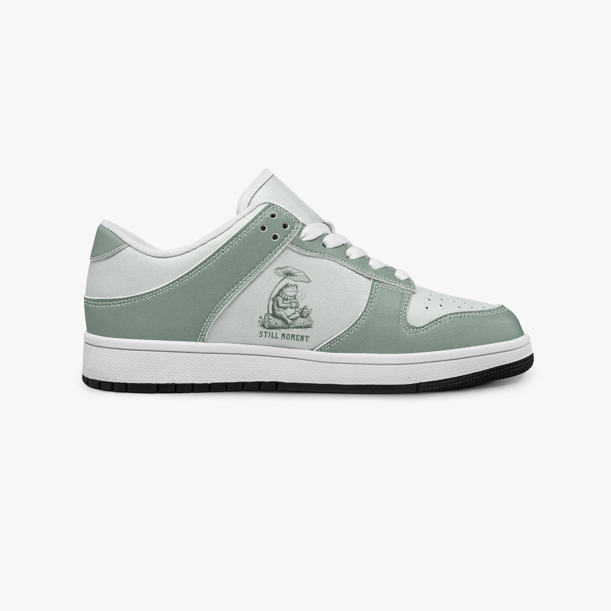 Side profile view of the right sneaker showcasing sage green leather overlays, frog graphic, white eyelet lacing, and contrasting dark outsole facing right.
