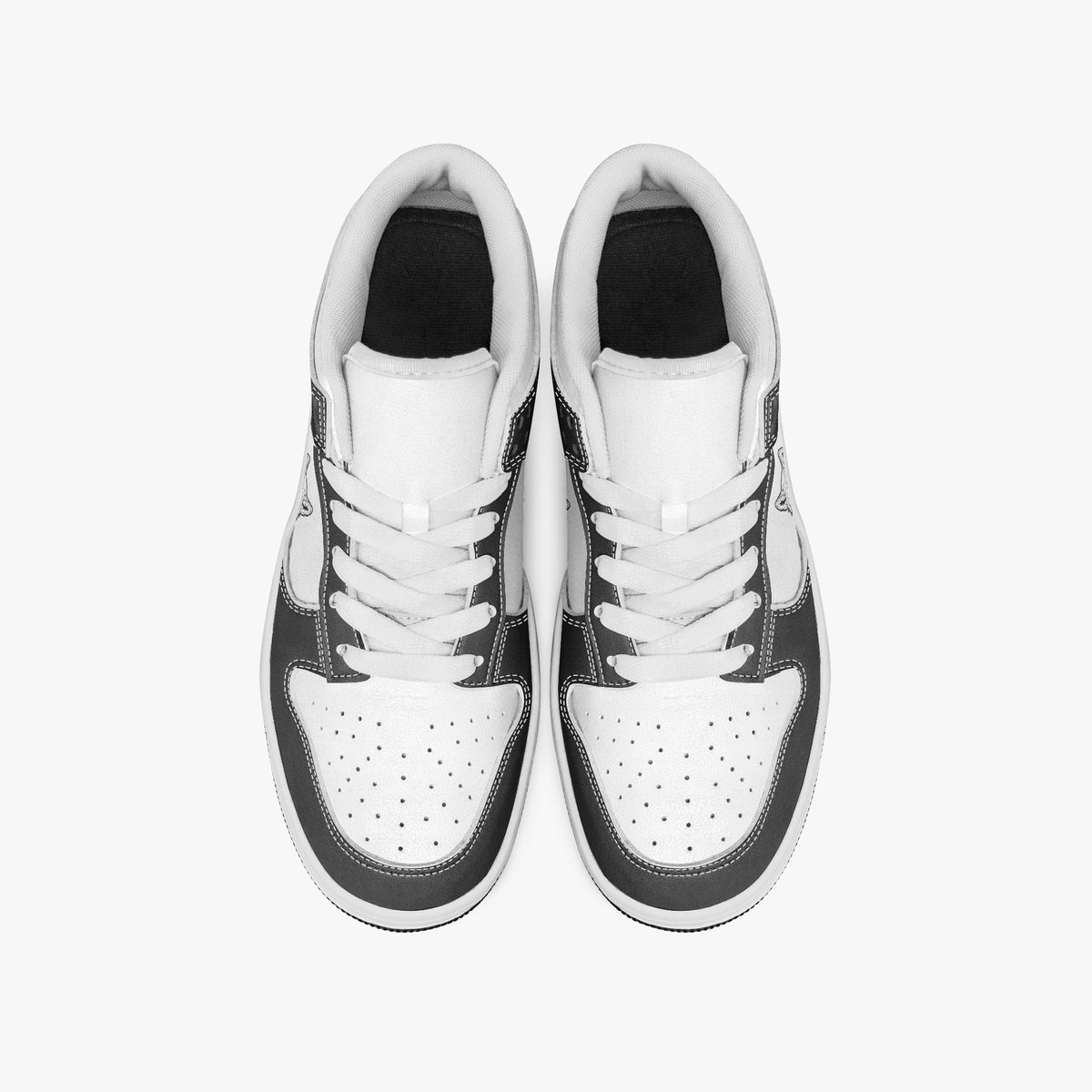 Overhead view of black and white sneakers showing clean white laces, white padded collar lining, and perforated white leather toe boxes.