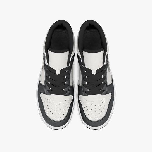 Overhead view of black and white sneakers displaying black laces, black padded collar lining, and perforated white leather toe boxes.