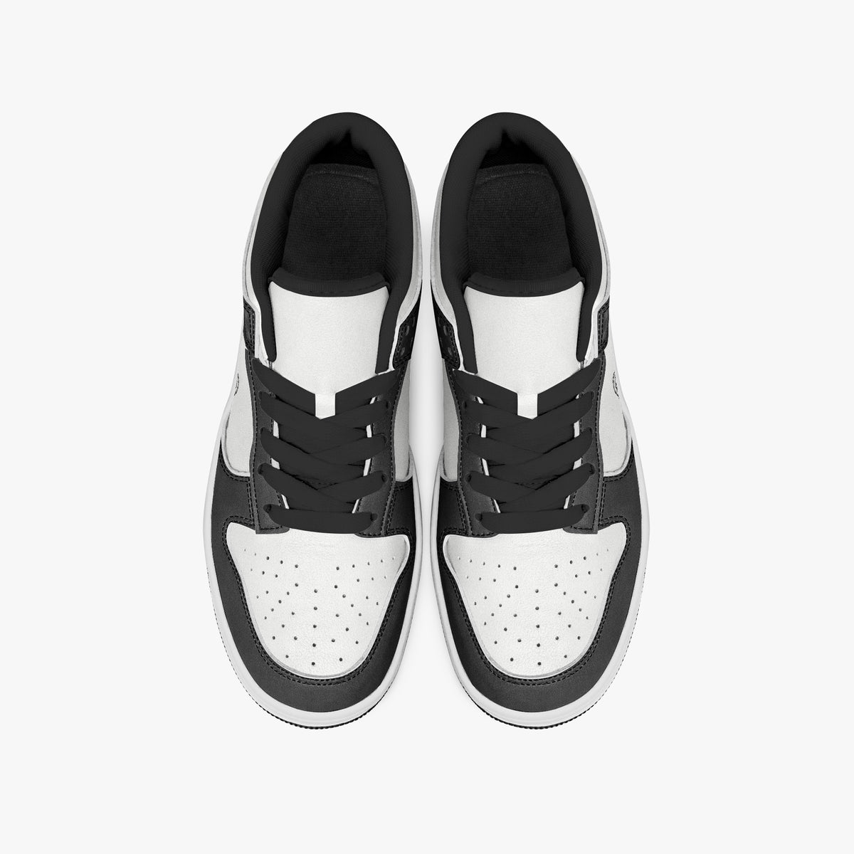 Overhead view of black and white sneakers displaying black laces, black padded collar lining, and perforated white leather toe boxes.
