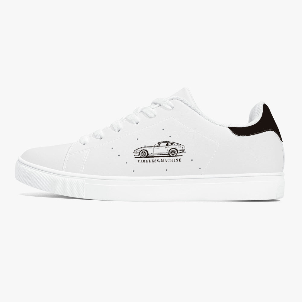 Side profile view of the left sneaker in smooth white leather, showcasing the vintage car graphic, black heel tab detail, white laces, and flat white rubber cupsole facing right.