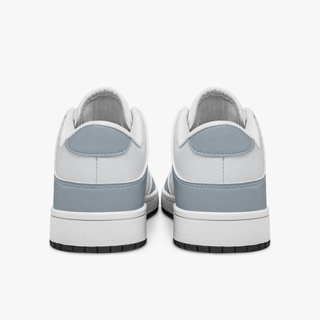 Rear view of slate blue-grey and white sneakers displaying blue-grey heel overlays, white leather collar panels, and two-tone white and black rubber outsoles.