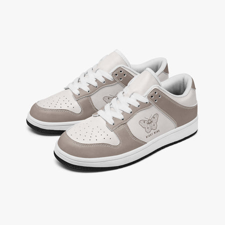 Angled three-quarter view of low-top sneakers in taupe grey-brown and off-white leather, featuring a moth graphic with "NIGHT WING", white laces, and a white inner lining.