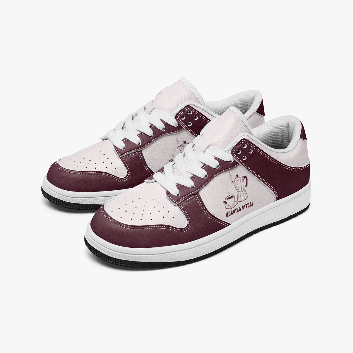 Angled three-quarter view of low-top sneakers in burgundy and pale pink leather, featuring a moka pot and coffee cup graphic with "MORNING RITUAL", white laces, and a white inner lining.
