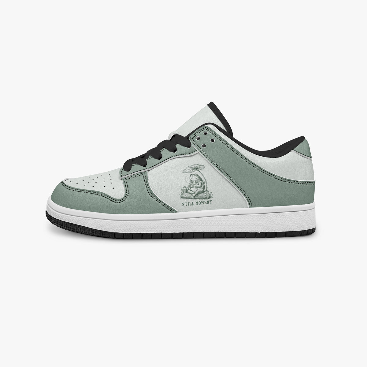 Side profile view of the left sneaker highlighting the sage green leather panels, frog graphic, black interior lining, and flat rubber sole facing right.