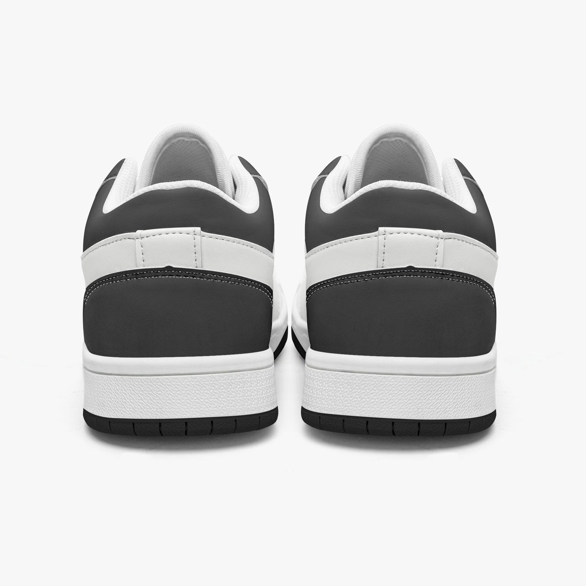 Rear view of black and white sneakers displaying dark charcoal heel overlays, white leather collar panels, white interior linings, and clean white midsoles above black outsoles.