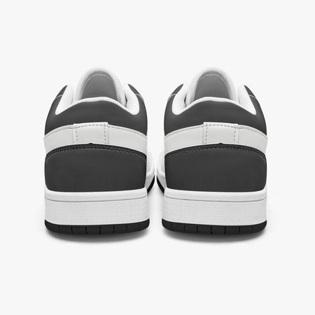 Rear view of black and white sneakers displaying dark charcoal heel overlays, white leather collar panels, white interior linings, and clean white midsoles above black outsoles.