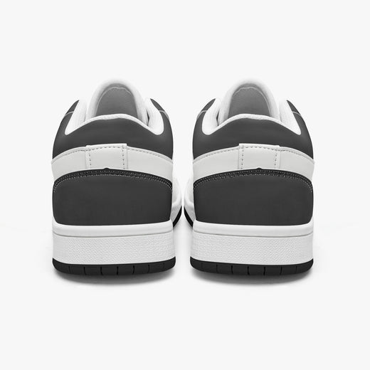 Rear view of black and white sneakers displaying dark charcoal heel overlays, white leather collar panels, white interior linings, and clean white midsoles above black outsoles.
