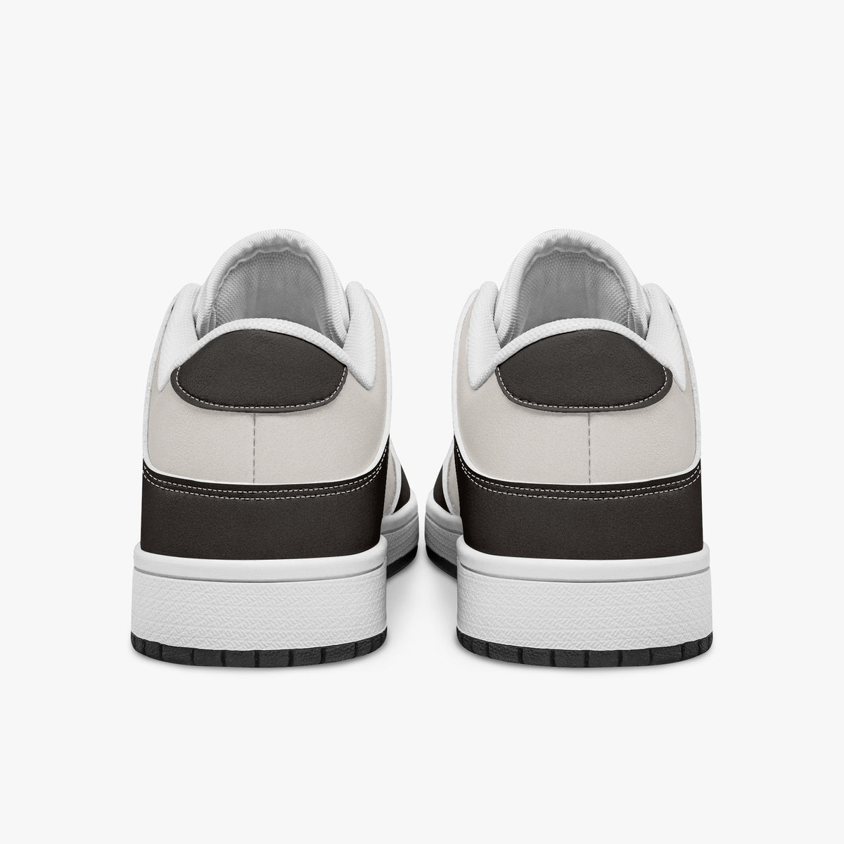 Rear view of dark brown and cream sneakers displaying espresso brown heel overlays, off-white leather collar panels, and two-tone white and black rubber outsoles.