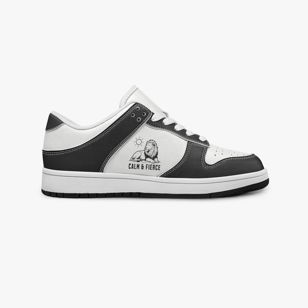 Side profile view of the right sneaker showcasing the black leather overlays, lion emblem, white eyelet lacing, and contrasting black outsole facing right.