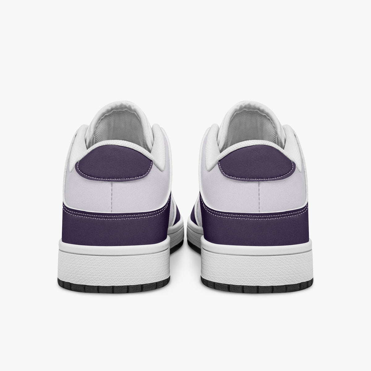 Rear view of deep purple and white sneakers displaying purple heel overlays, white leather collars, and two-tone white and black rubber outsoles.