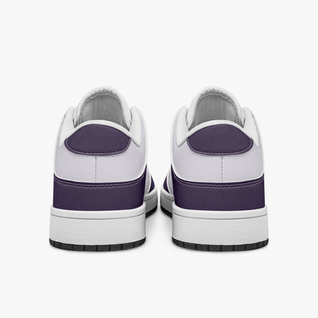 Rear view of deep purple and white sneakers displaying purple heel overlays, white leather collars, and two-tone white and black rubber outsoles.
