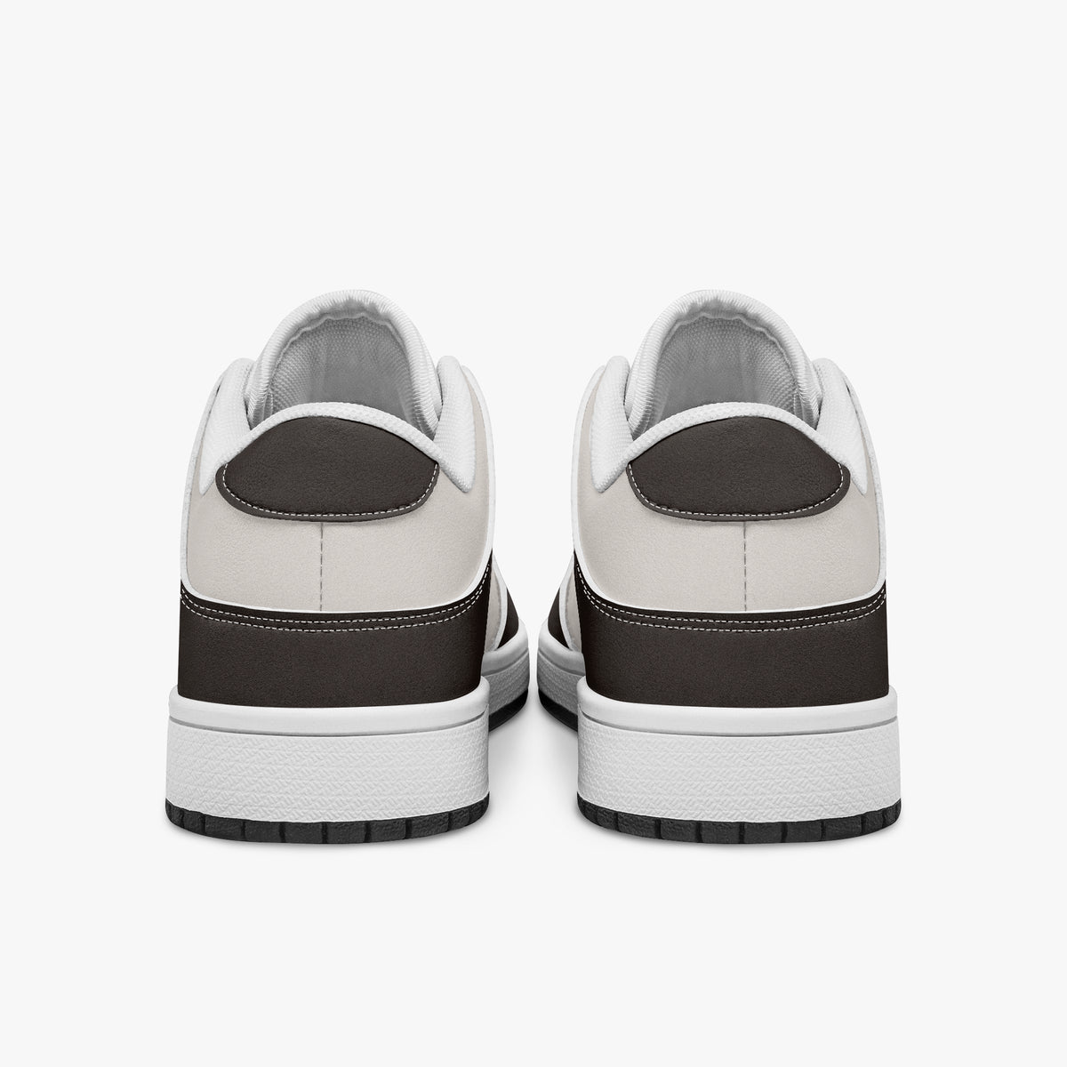 Rear view of dark brown and cream sneakers displaying espresso brown heel overlays, off-white leather collar panels, and two-tone white and black rubber outsoles.