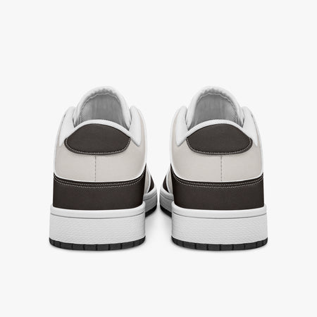 Rear view of dark brown and cream sneakers displaying espresso brown heel overlays, off-white leather collar panels, and two-tone white and black rubber outsoles.