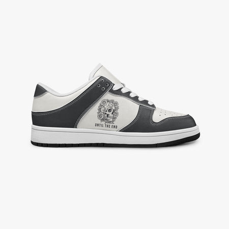 Side profile view of the right sneaker showcasing the black leather overlays, floral skull emblem, white eyelet lacing, and contrasting black outsole facing right.