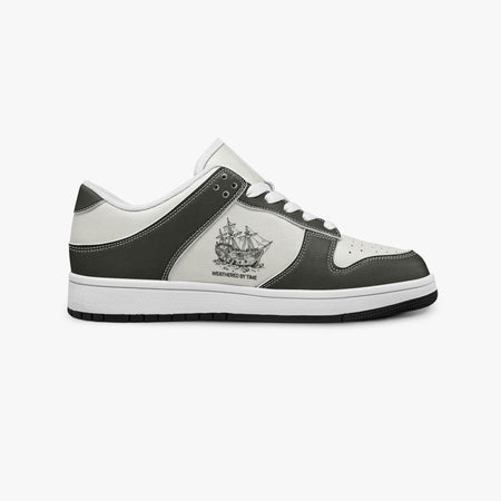 Side profile view of the right sneaker showcasing the dark leather overlays, sailing ship emblem, white eyelet lacing, and contrasting black outsole facing right.