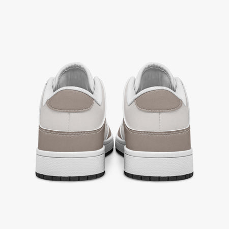 Rear view of taupe and off-white sneakers displaying taupe heel overlays, light off-white collar panels, and two-tone white and black rubber outsoles.