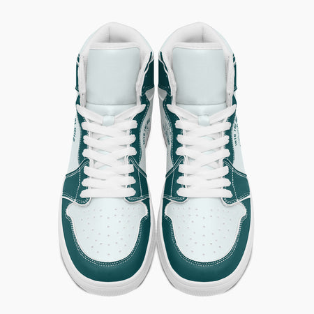 Overhead top-down view of high-top sneakers highlighting dark teal eyestays, white lacing, and perforated white leather vamps.