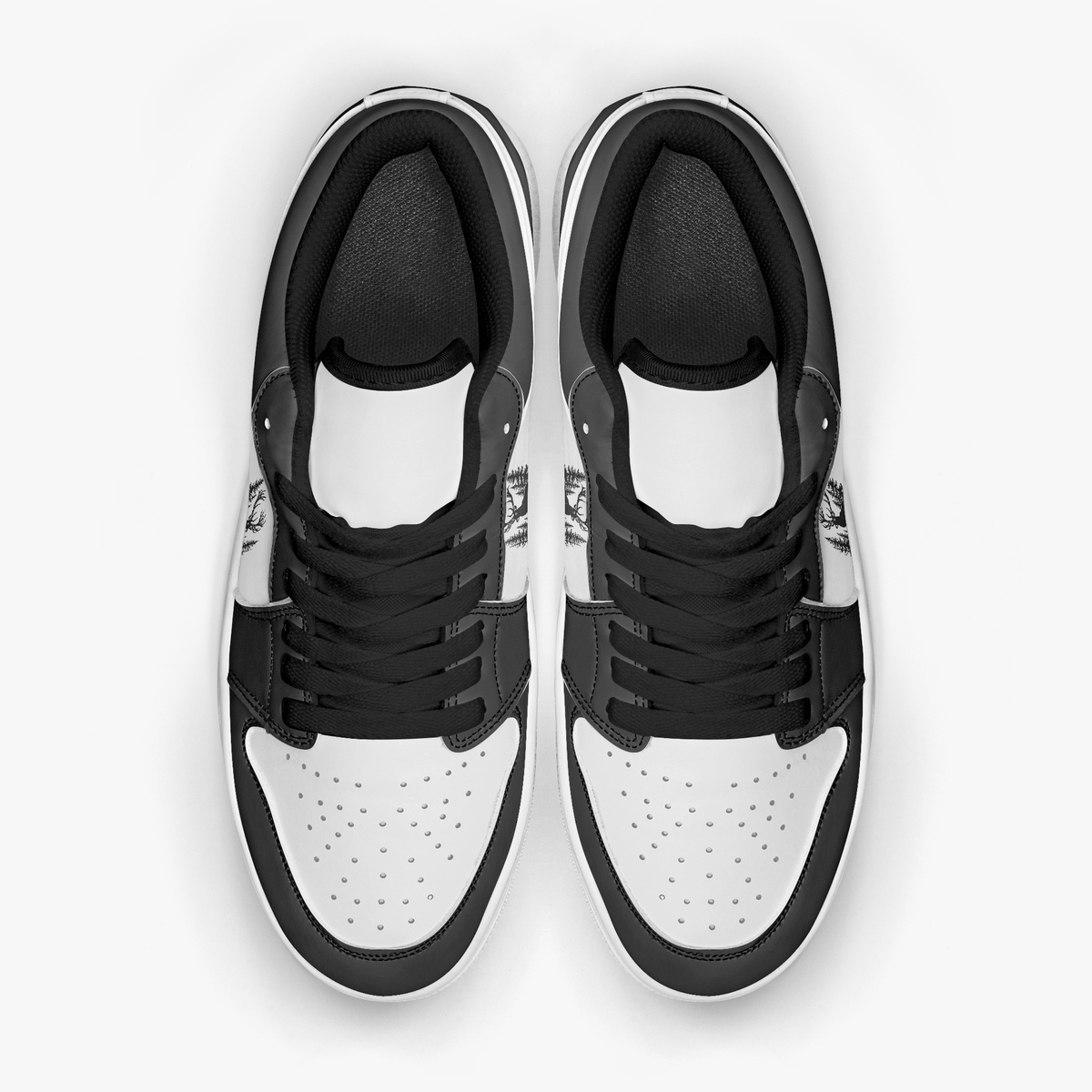 Overhead view of black and white sneakers displaying black laces, black padded collar lining, and perforated white leather toe boxes.