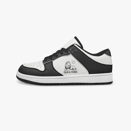 Side profile view of the left sneaker highlighting the black leather panels, lion emblem, black interior lining, and flat rubber sole facing right.