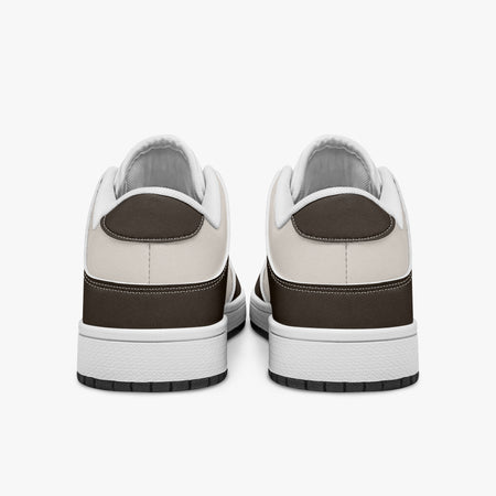 Rear view of dark brown and cream sneakers displaying dark brown heel overlays, off-white leather collar panels, and two-tone white and black rubber outsoles.