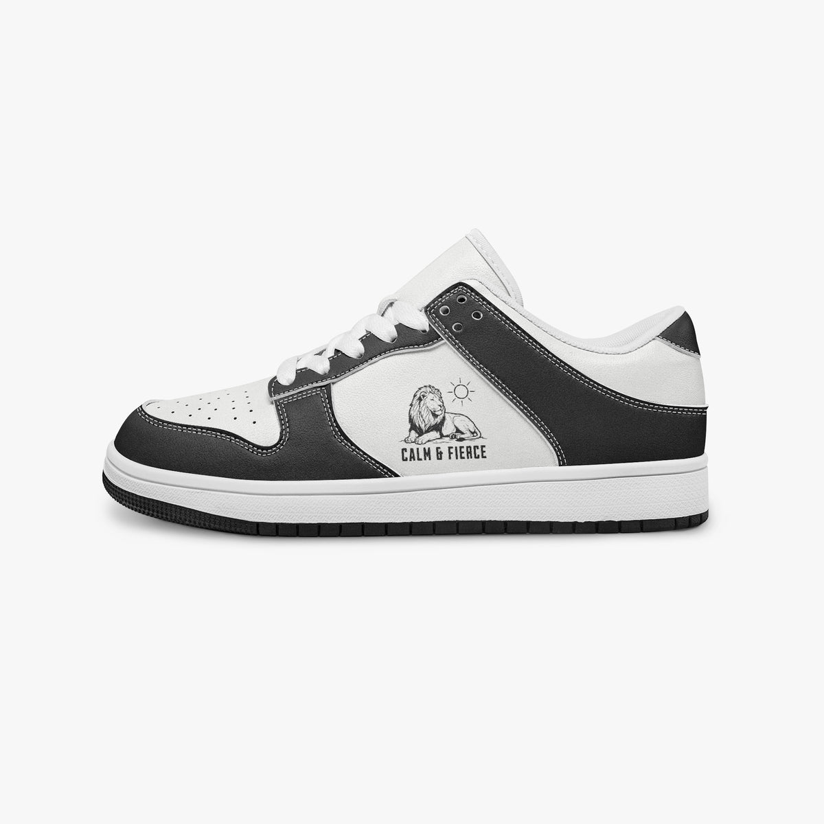 Side profile view of the left sneaker in black and white leather, highlighting the "CALM & FIERCE" lion illustration, white laces, white interior lining, and flat rubber sole facing right.