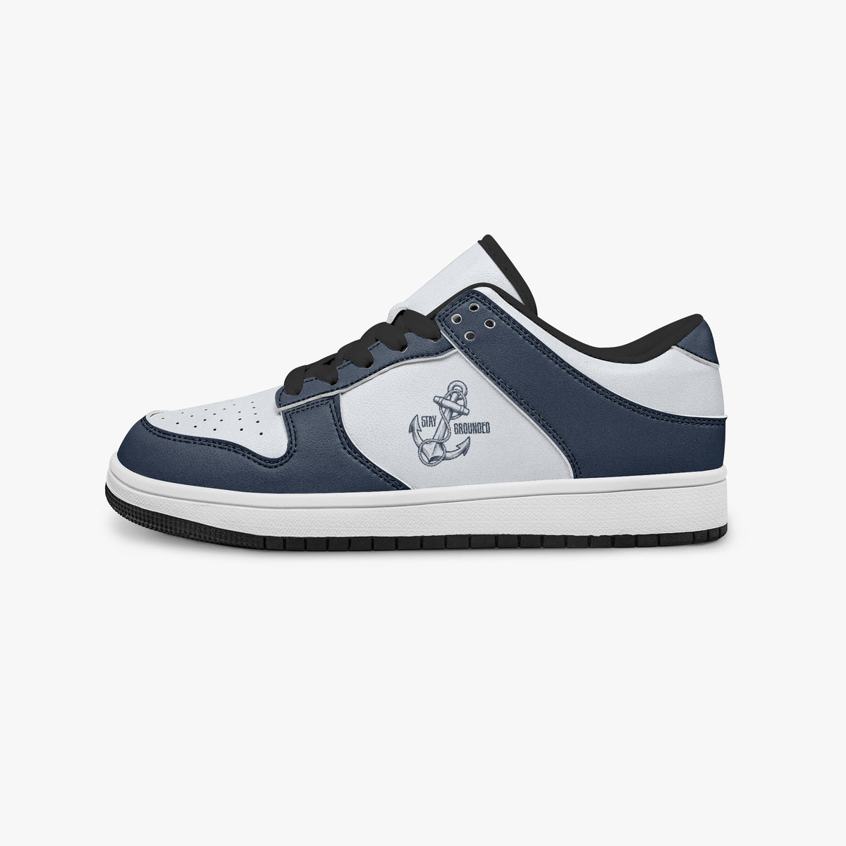 Side profile view of the left sneaker highlighting the navy blue leather overlays, "STAY GROUNDED" anchor print, and flat rubber sole facing right.