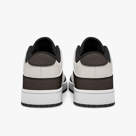 Rear view of brown and cream sneakers showing dark brown heel overlays, off-white leather collars, and black interior collar lining above white midsoles.