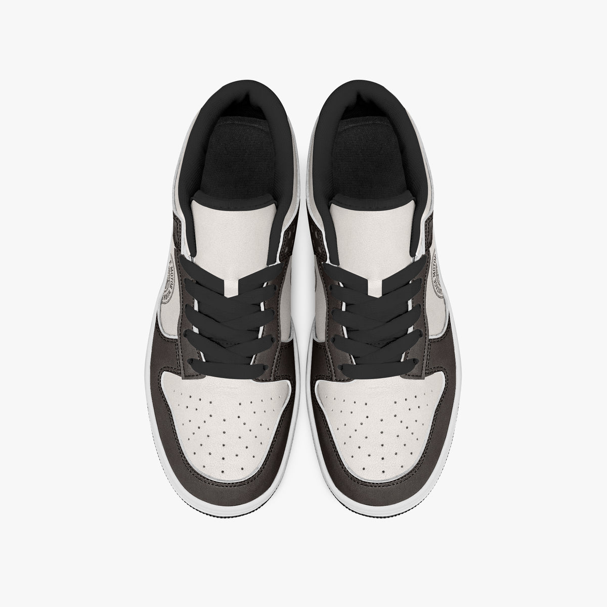 Overhead view of dark brown and cream sneakers displaying black laces, black padded collar lining, and perforated cream leather toe boxes.