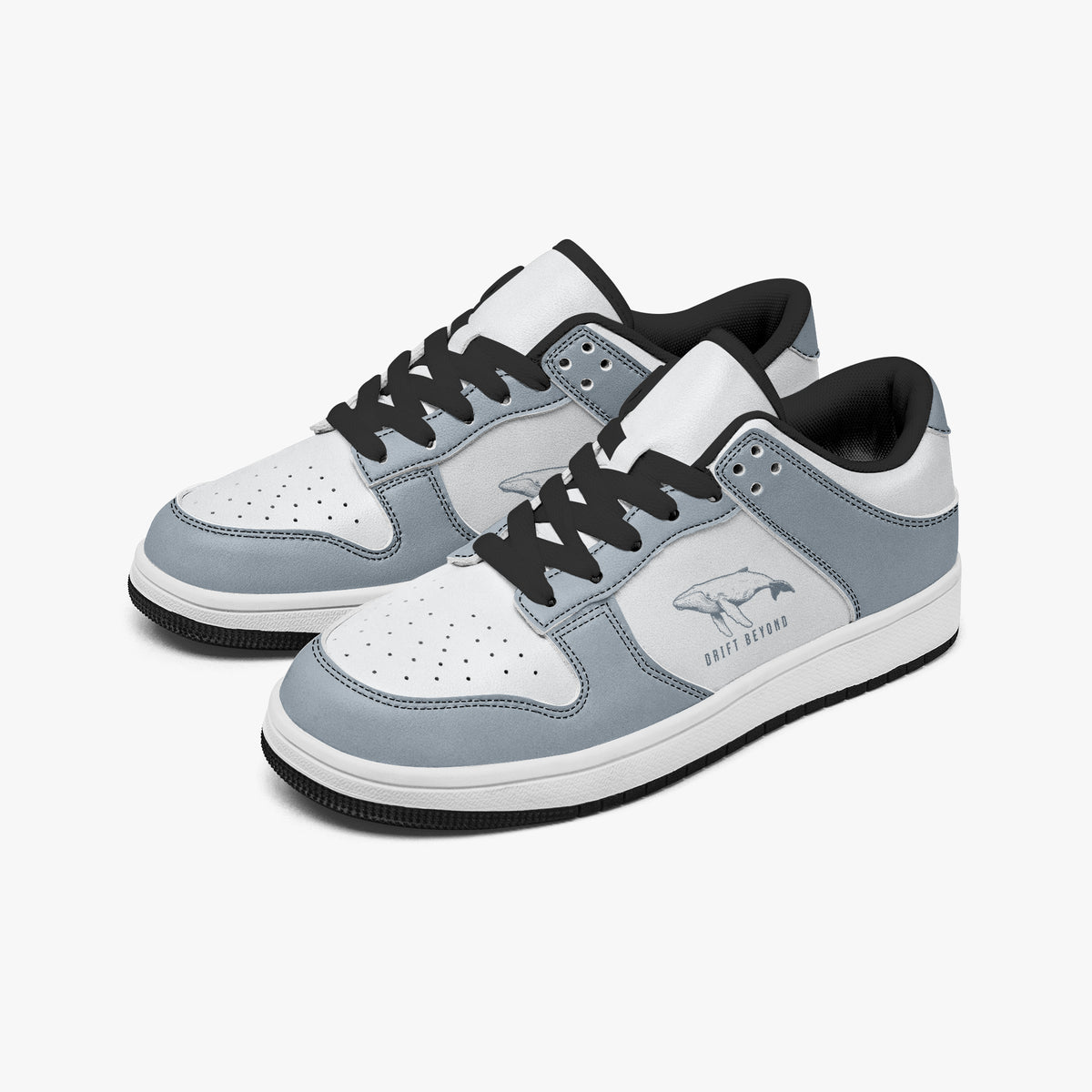 Angled three-quarter view of low-top sneakers in slate blue-grey and white leather, featuring a whale graphic with "DRIFT BEYOND", black laces, and a black inner lining.